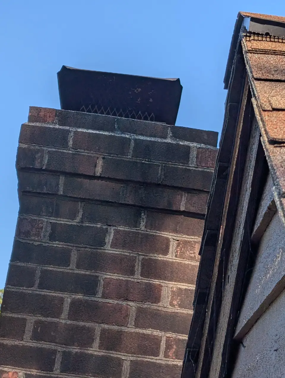 Chimney crown and cap on a brick chimney, photographed during an inspection