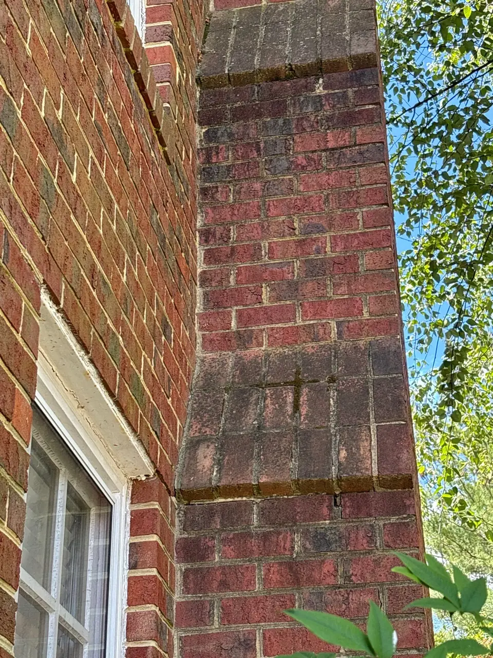 Exterior brick chimney chase on the side of a house