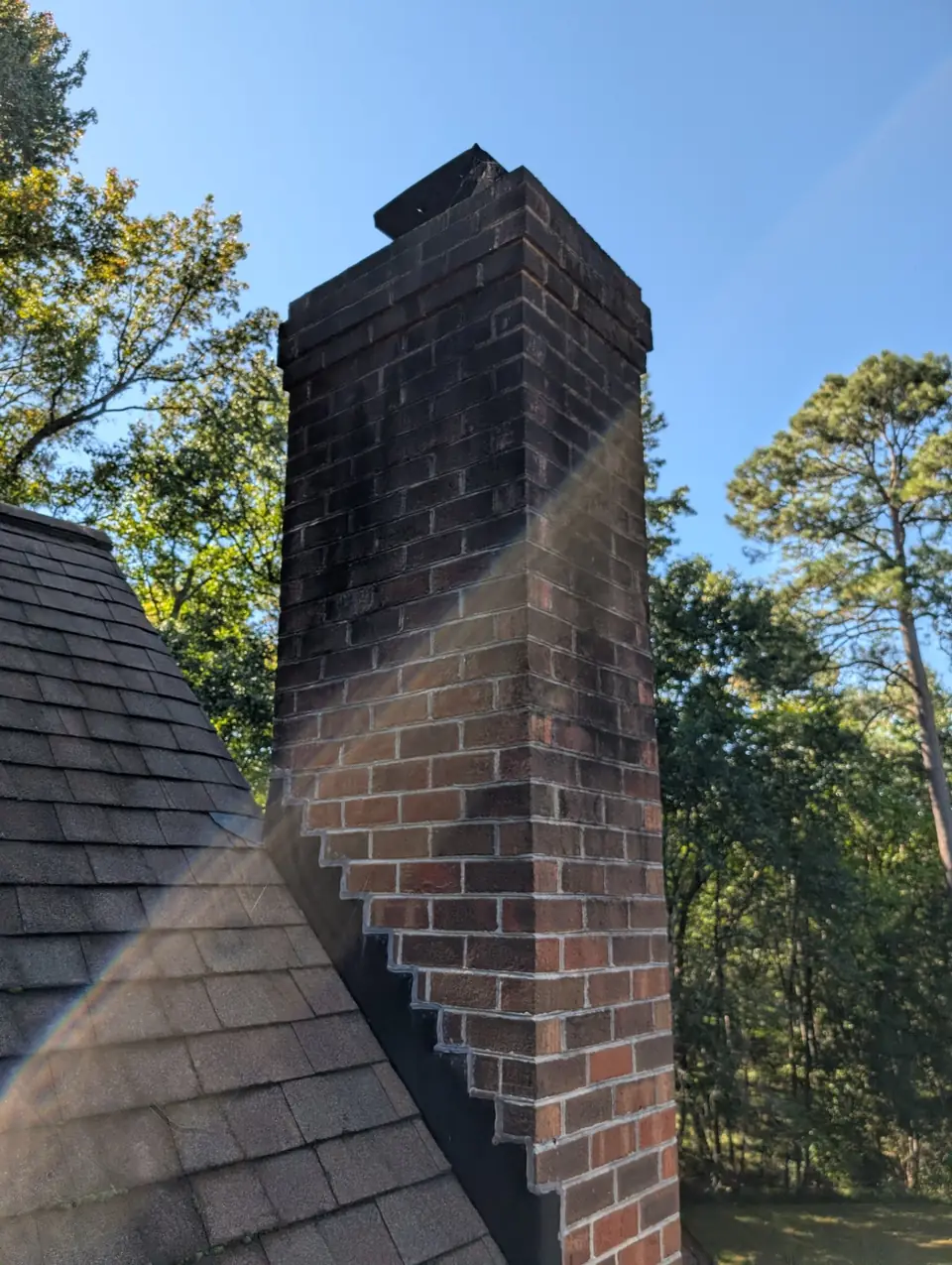 Brick chimney passing through a shingle roof