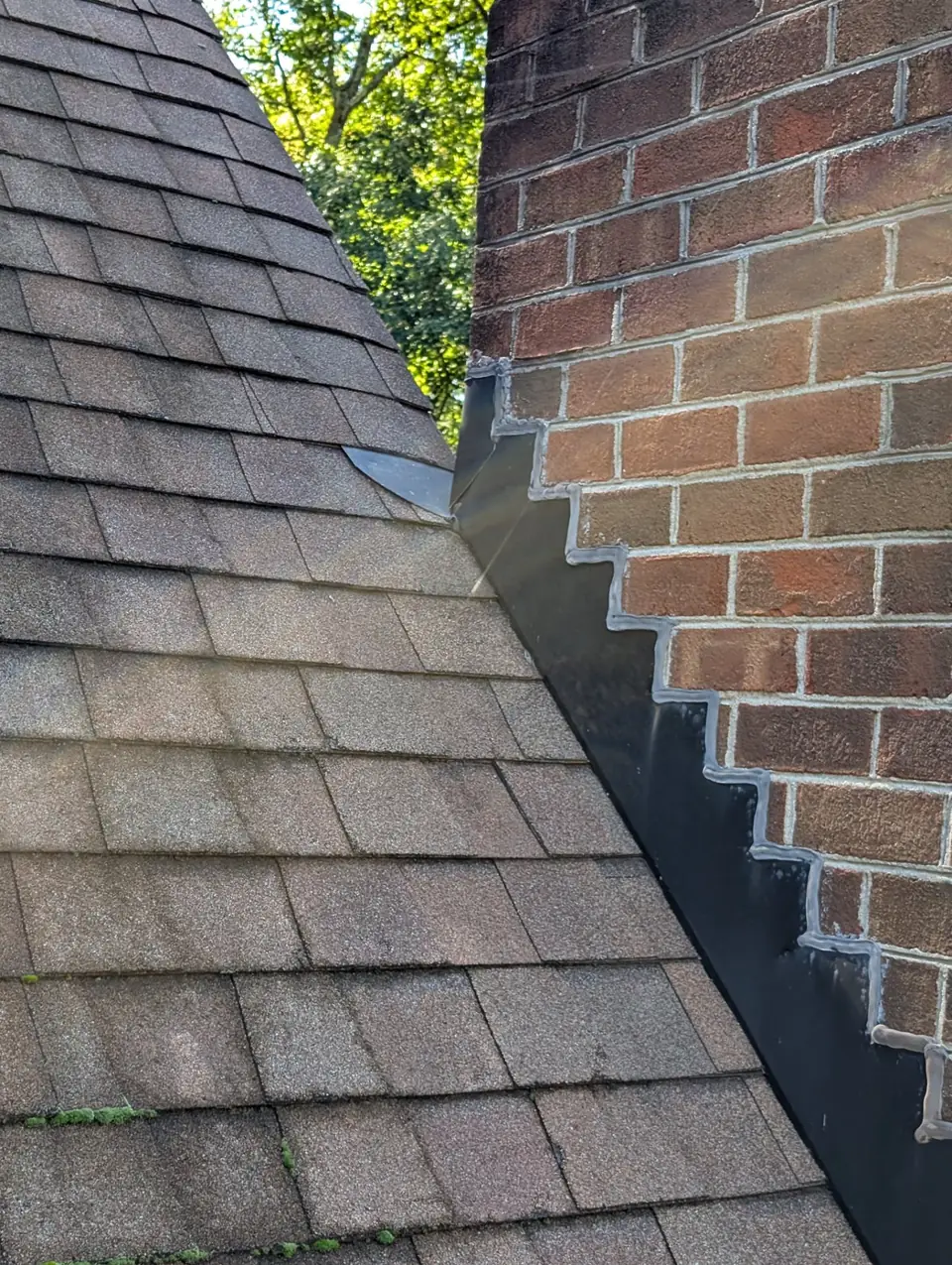 Brick chimney and step flashing on a shingle roof