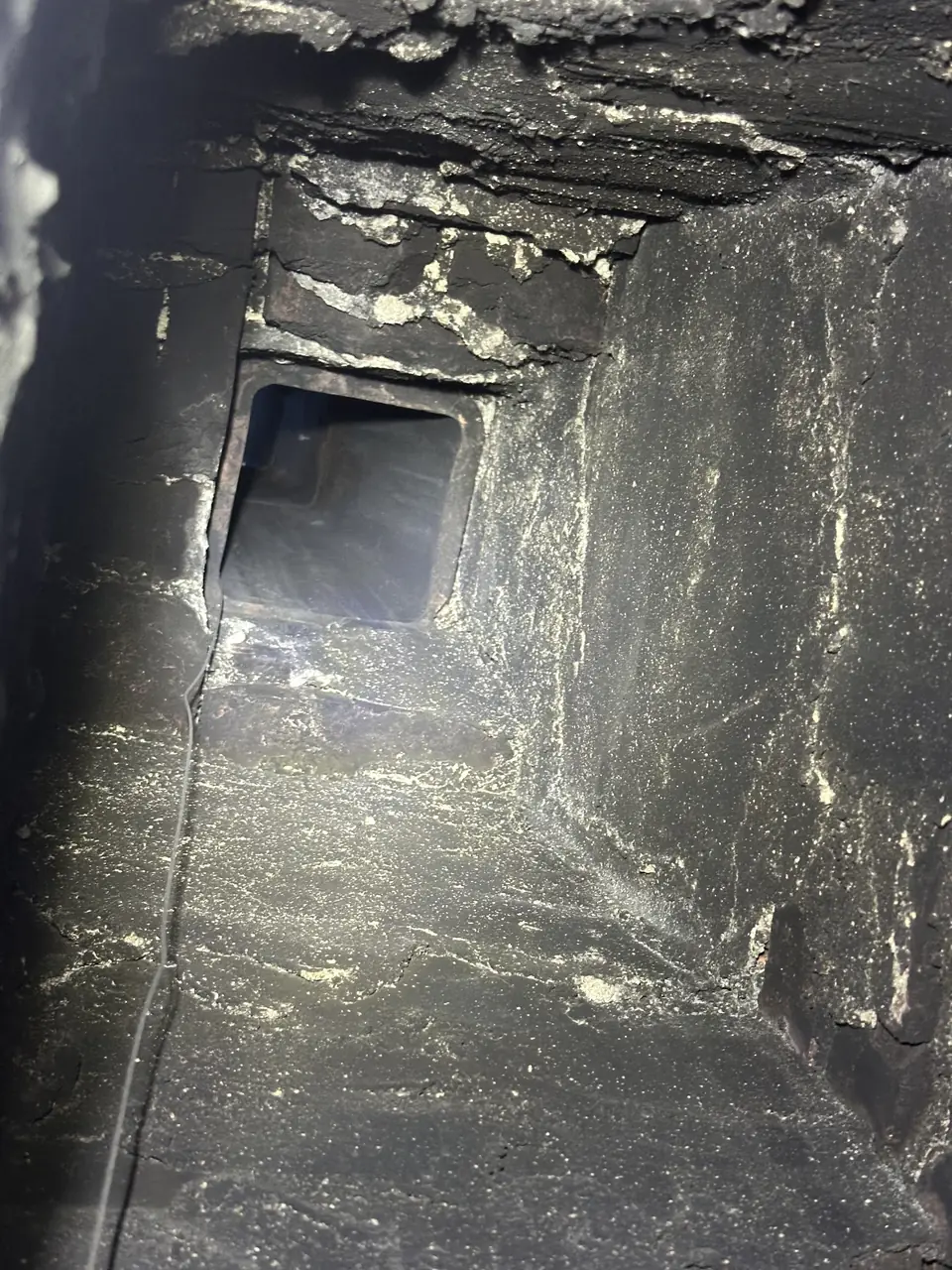 Camera view inside a masonry flue with creosote on the walls