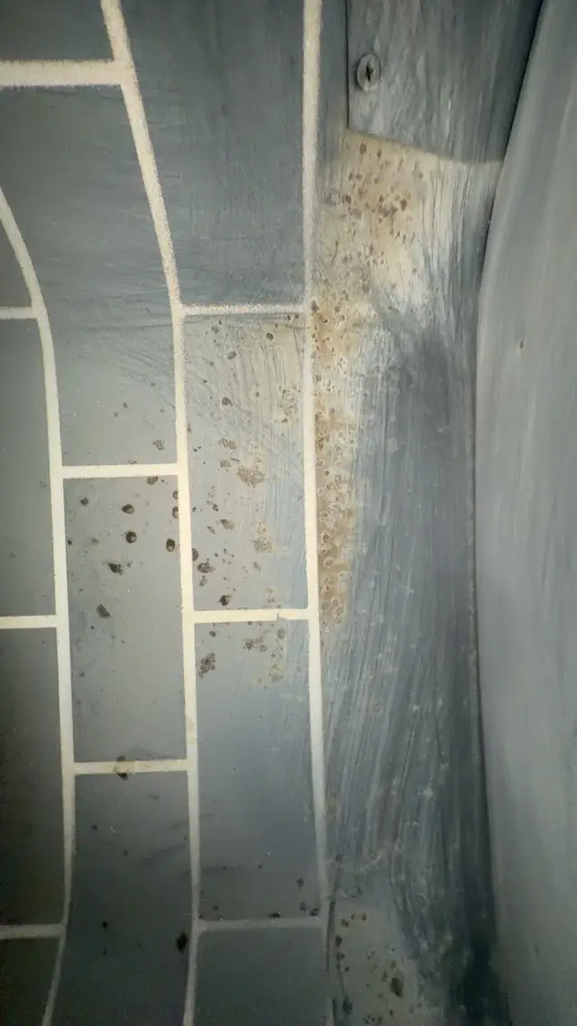 Inside a clay-tile chimney flue liner showing soot deposits