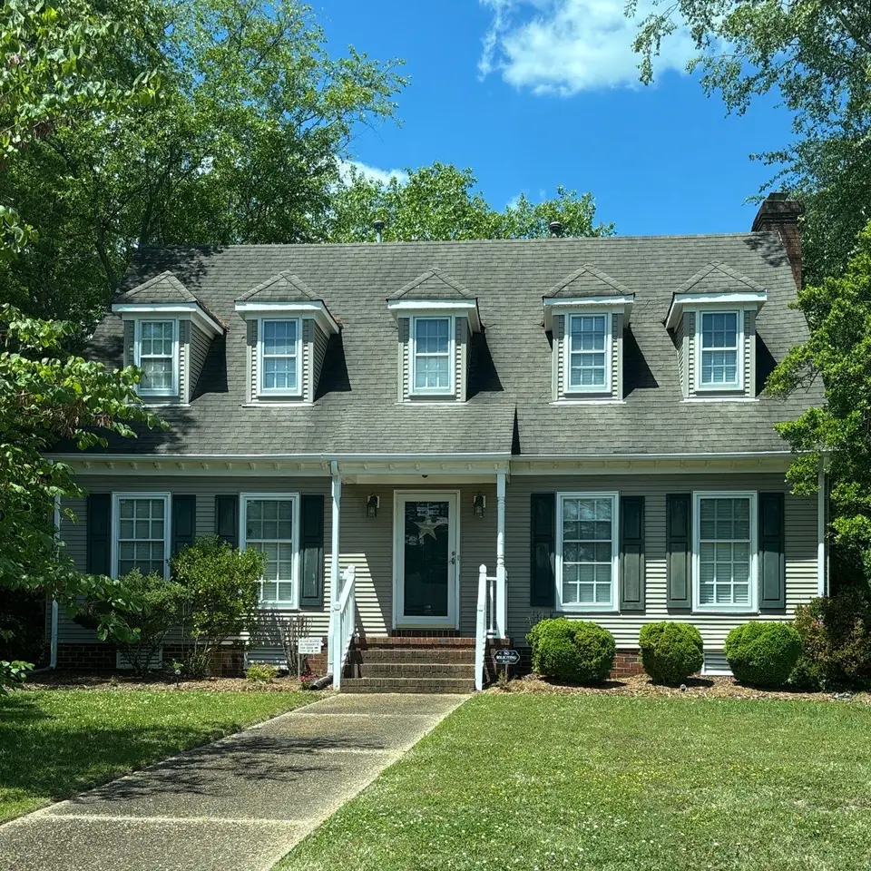 Two-story home with dormer windows and a brick chimney