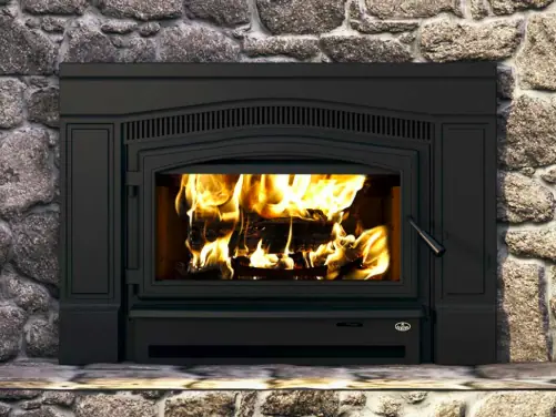 Wood stove insert burning in a stone fireplace